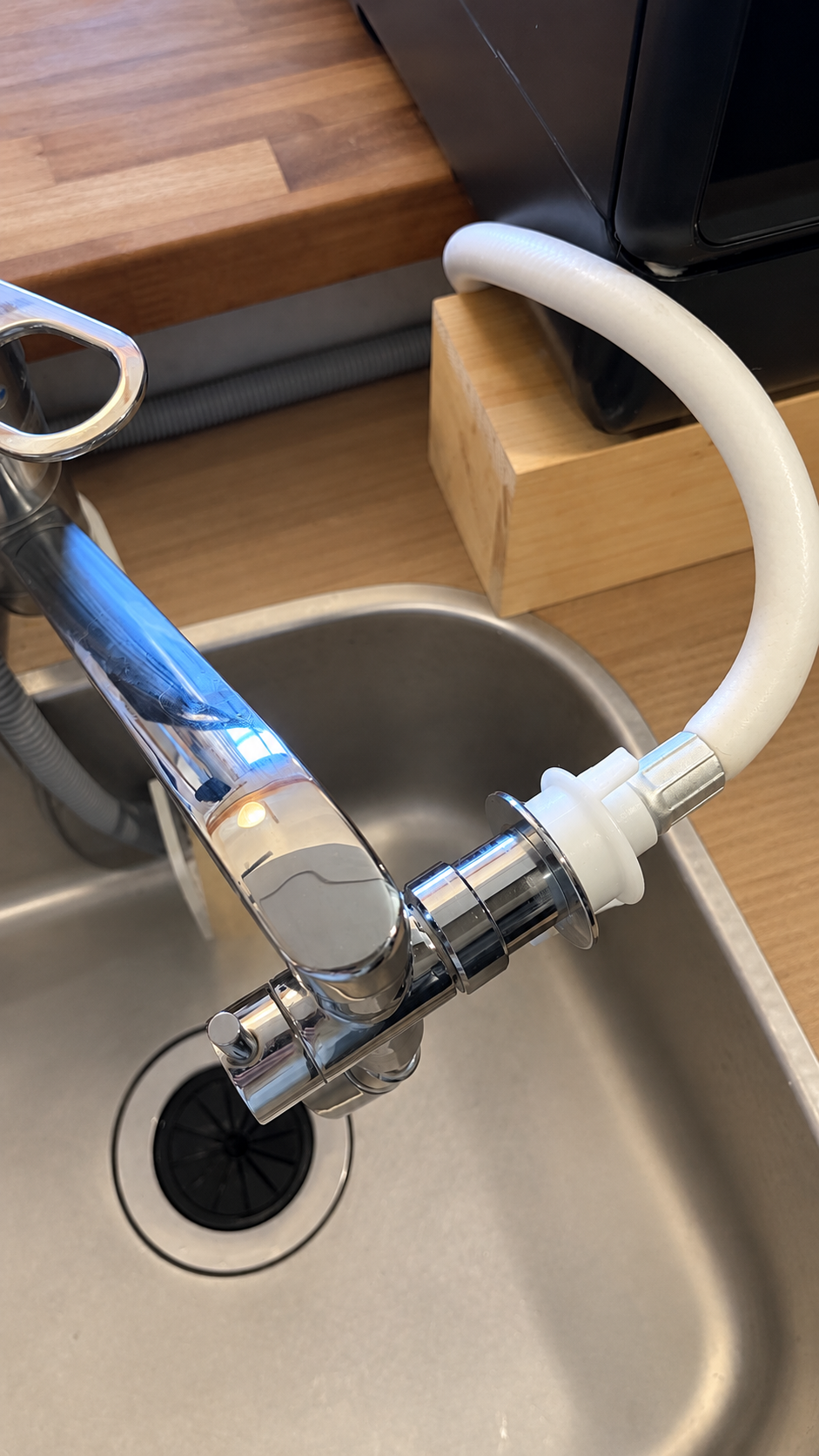 蛇口から白い給水ホースへつないでいる様子。